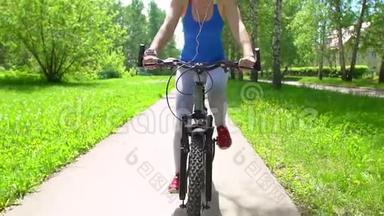 女人骑着一辆带智能<strong>手表心率</strong>监视器的自行车。 智能<strong>手表</strong>的概念。 戴眼镜的快乐年轻女子